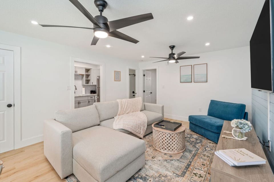 Relaxed living room with sectional, armchair, and soft neutral tones.
