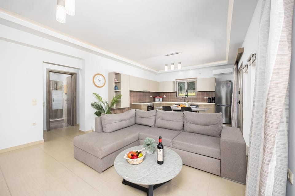 Open-plan living room with sofa, dining area, kitchen, A/C, WiFi internet, and satellite TV