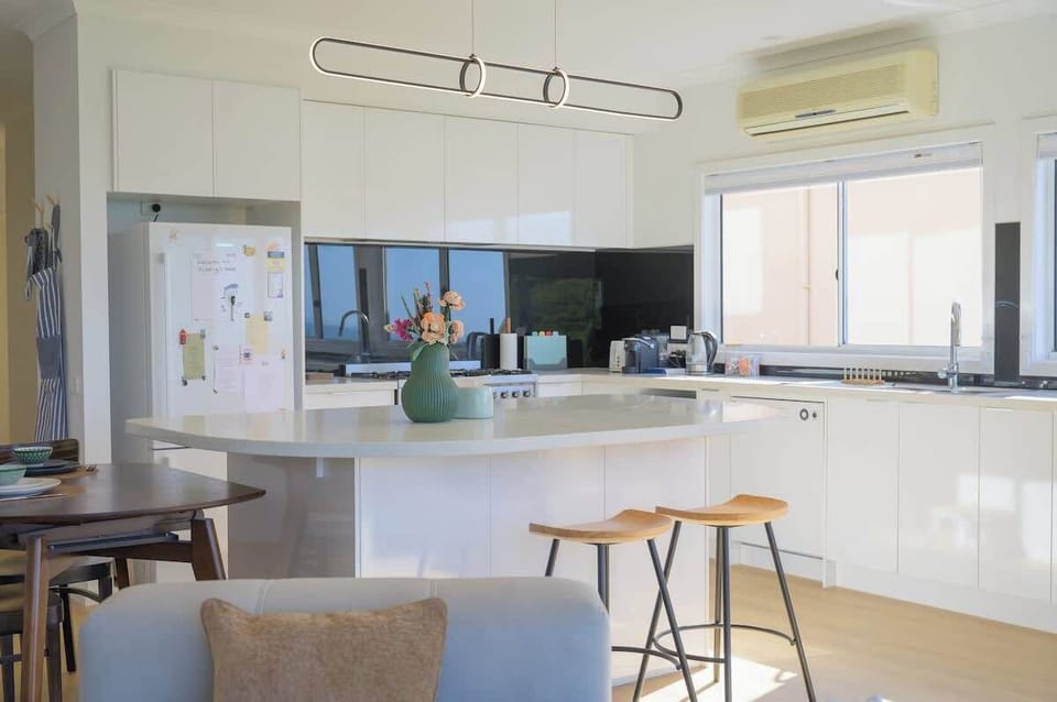 Full kitchen downstairs. The modern kitchen is equipped with top-tier appliances including an Asko dishwasher, Smeg cooktop, coffee machine, kettle. Whether you have simple or complex kitchen needs, this kitchen can accommodate any cook with ease.