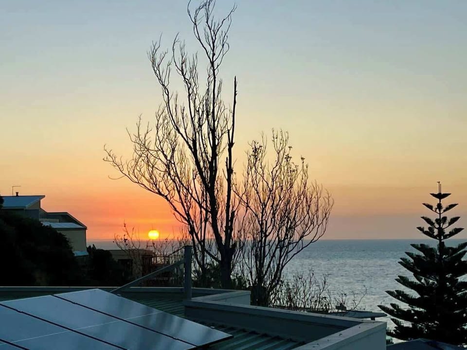 Experience unparalleled tranquillity while watching the sunset over the sea from Pudding’s Home, offering a particularly warm and serene experience during Melbourne's winter.