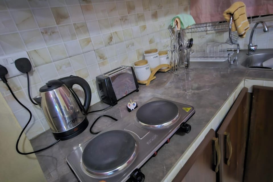 Kitchen area includes a fridge , microwave, kettle , toaster , tea , coffee , sugar , cooking utensils.