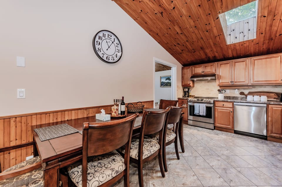 The dining area provides a warm and intimate setting, perfect for family meals, under the charm of wood-paneled ceilings.