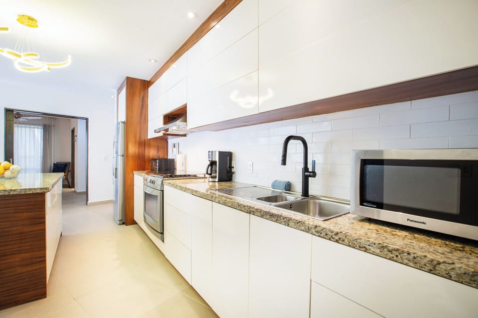 Modern Kitchen & Dining Area – Fully equipped kitchen with sleek appliances and a granite island, perfect for preparing meals at home.