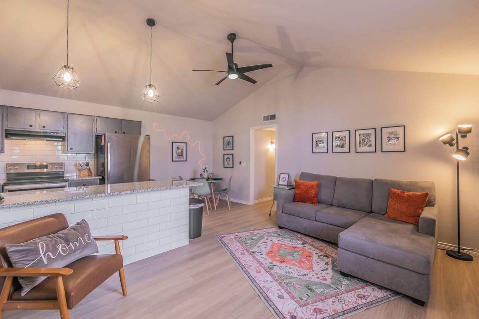 Open Living area to Dining and Kitchen. Couch is a Q sleeper