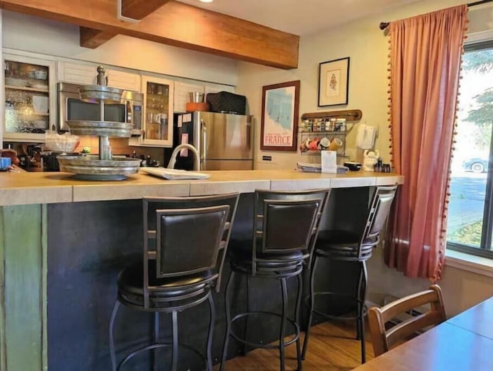 Counter and barstools looking into galley kitchen
