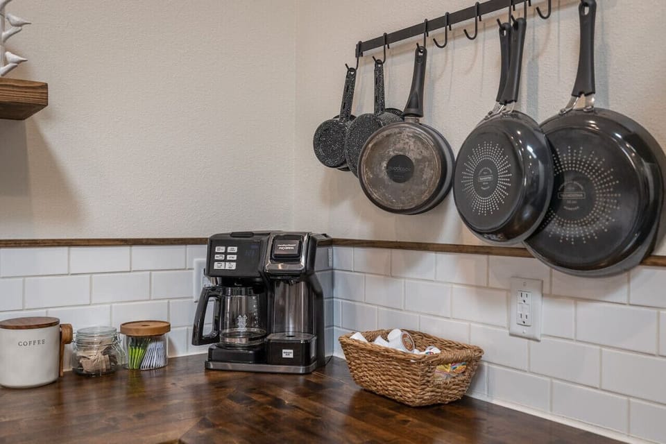The kitchen is equipped with a coffee maker and a variety of pots and pans, ensuring you’re ready for everything from your morning brew to a full family dinner.