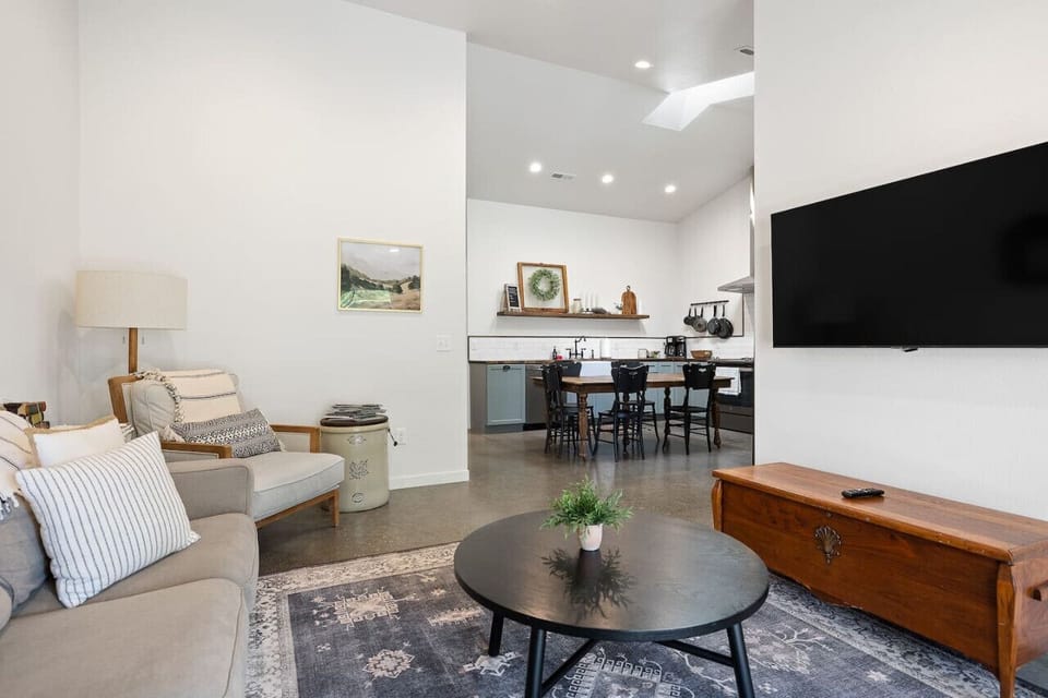 The inviting living room features a comfortable seating area and a large TV, perfect for relaxing and enjoying movie nights after a day of exploring.