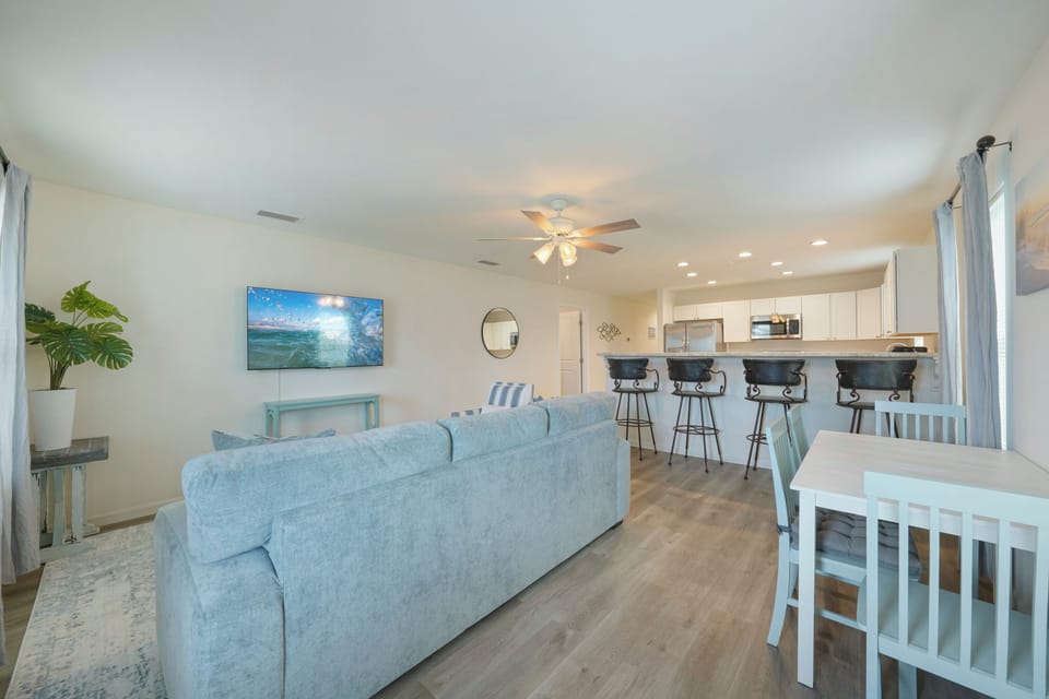 Spacious living room.  Dining room table, and a kitchen island.