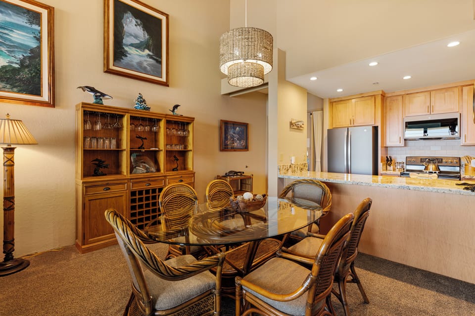 Spacious dining area featuring a stunning wicker chandelier, ideal for family meals or entertaining guests while enjoying beachside views.