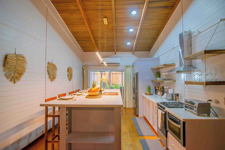 The modern kitchen features stainless steel appliances and an island for four.