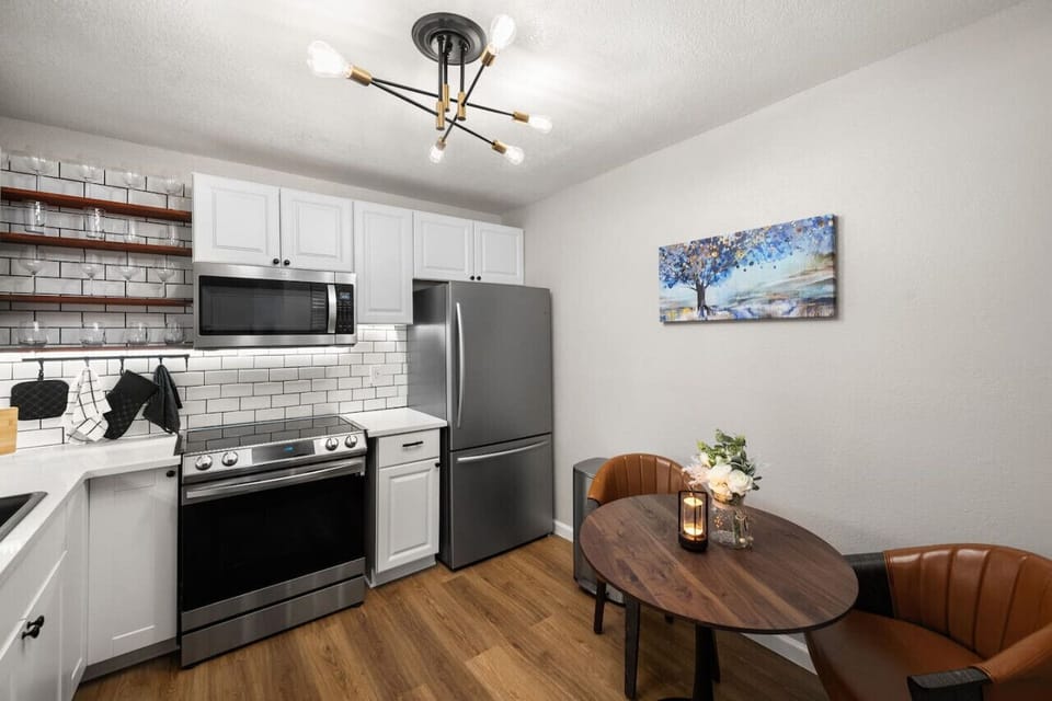 Fully stocked kitchen and dining area with modern appliances, wine glasses, coffee machine, and all you need for you stay!