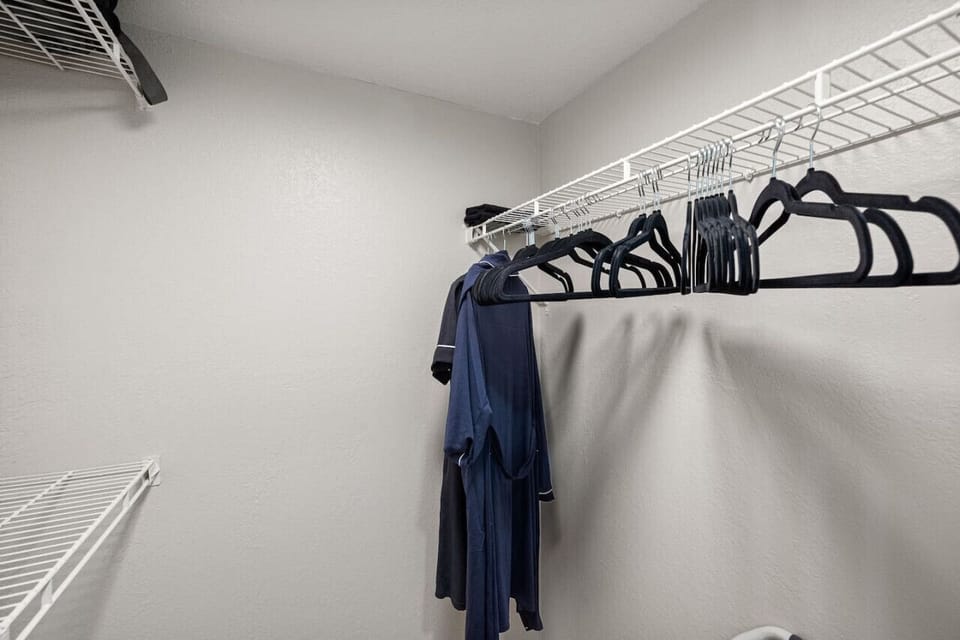 Bedroom closet with Hangers, shelves, and bath robes