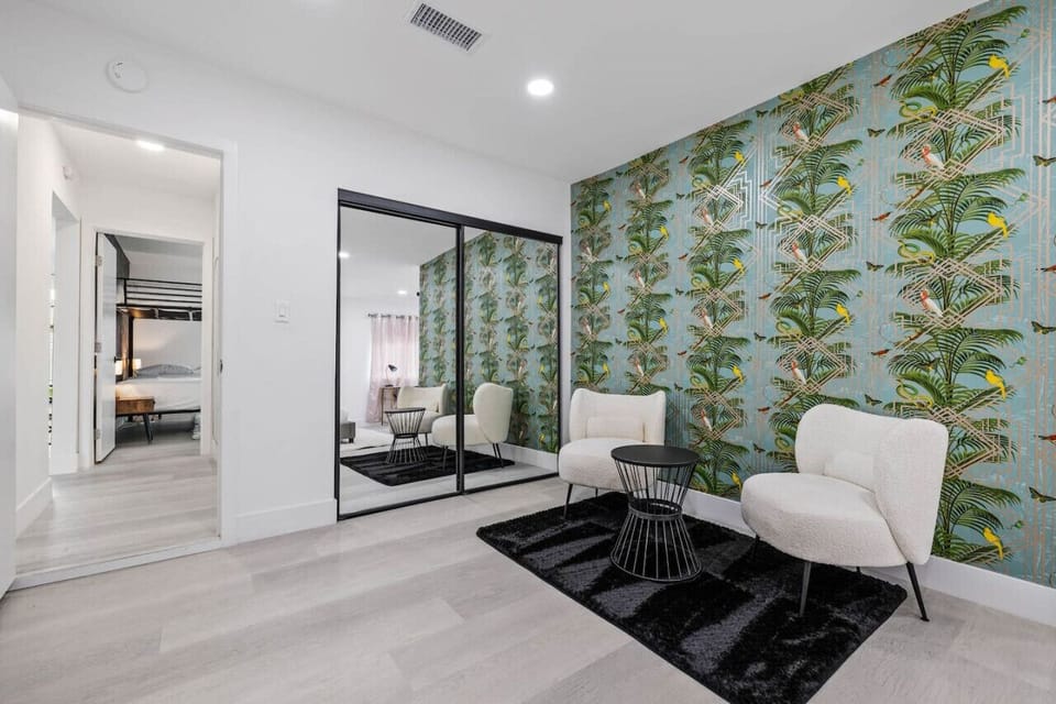 Contemporary bedroom w/ mirrored closet, bold wallpaper & a polished, modern style.