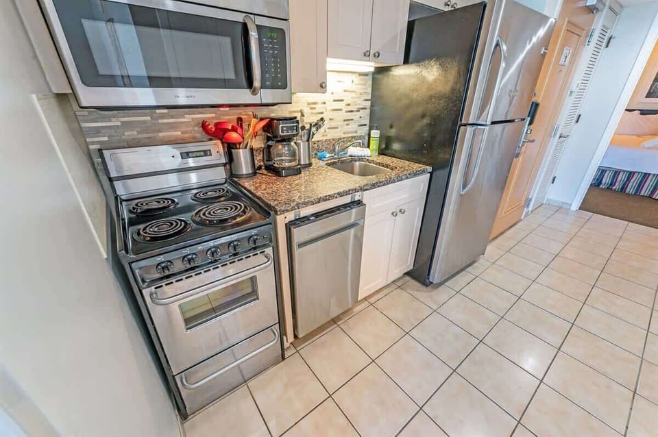 - Fully equipped kitchen featuring stainless steel appliances and granite countertops - Compact yet functional space with everything needed for home cooked meals - Stylish backsplash and modern touches make cooking a delight