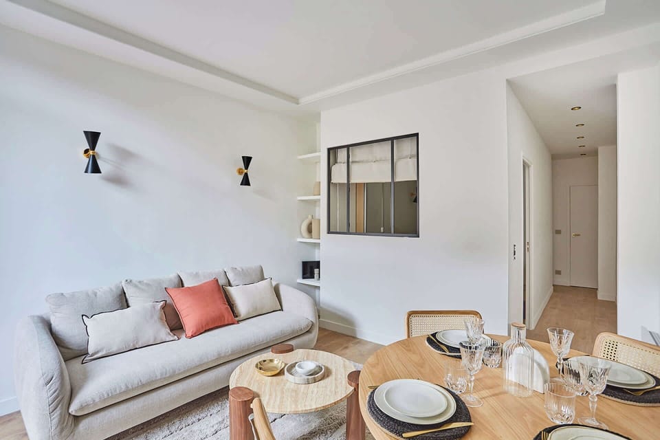 Salon avec canapé lit, TV, et espace repas pour 4 personnes