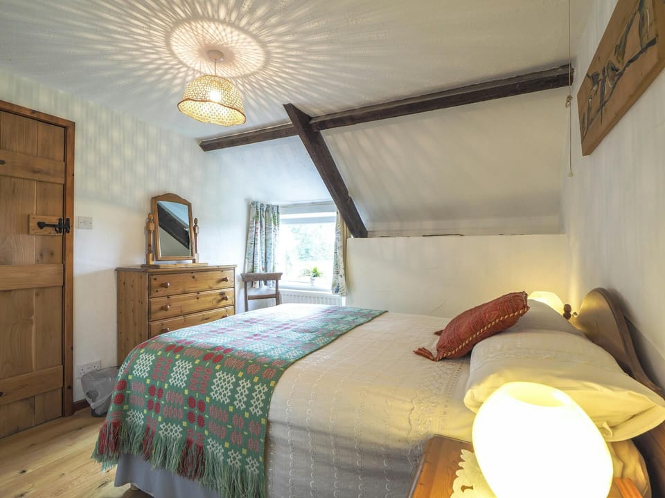 Double bed, bedside tables with lamps. Chest of drawers with mirror. Wooden wall art