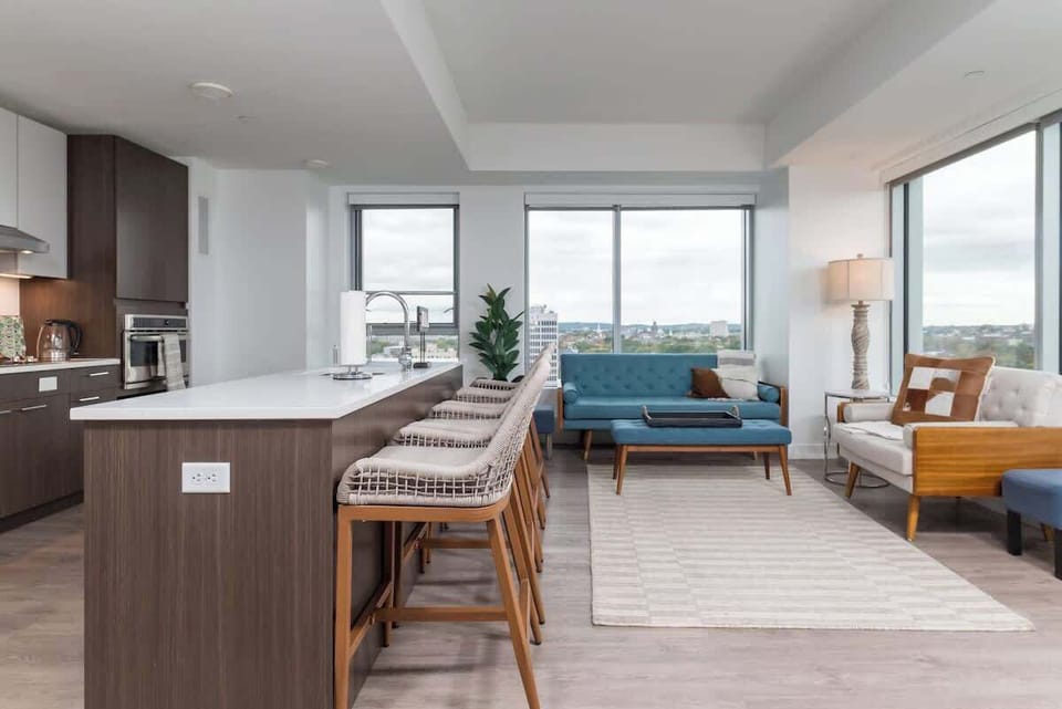 A full view of the kitchen, dining area seating and living room. All in one spacious and open layout providing a connecting feeling with your family and friends.
