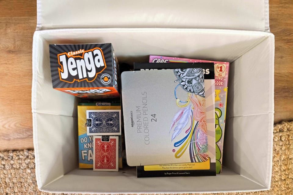 A collection of board games, playing cards, and colored pencils for family-friendly entertainment.