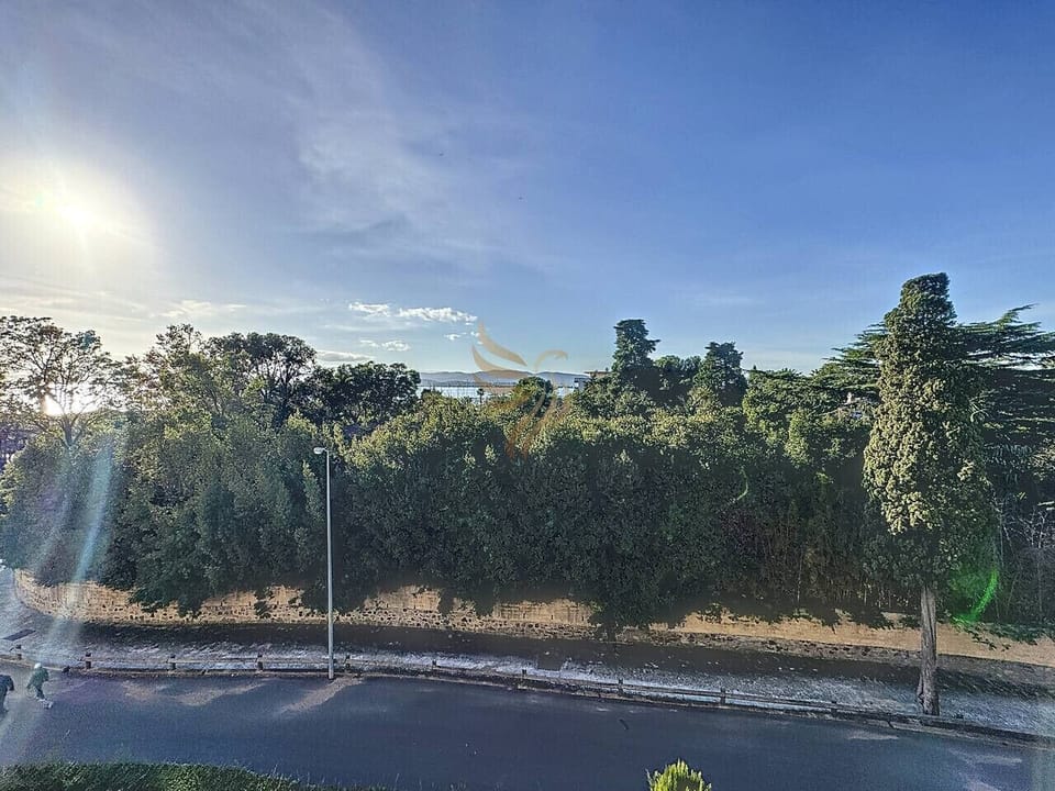 Environnement verdoyant avec vue partielle sur la mer, offrant une atmosphère paisible et relaxante.