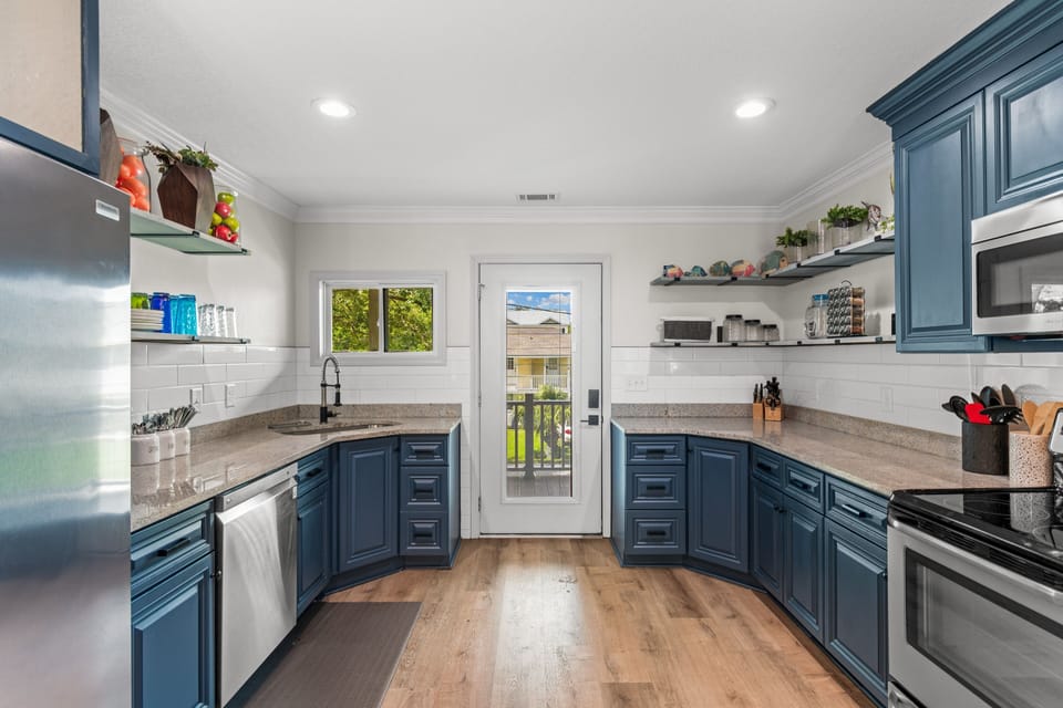 You'll love cooking in this spacious kitchen with elegant blue cabinets, granite counters, and modern appliances that make meal prep a joy.