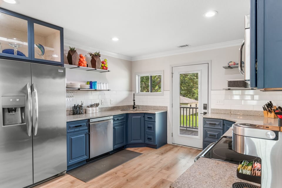 Your fully equipped kitchen awaits with modern appliances, granite counters, and French doors opening to outdoor spaces for culinary adventures.