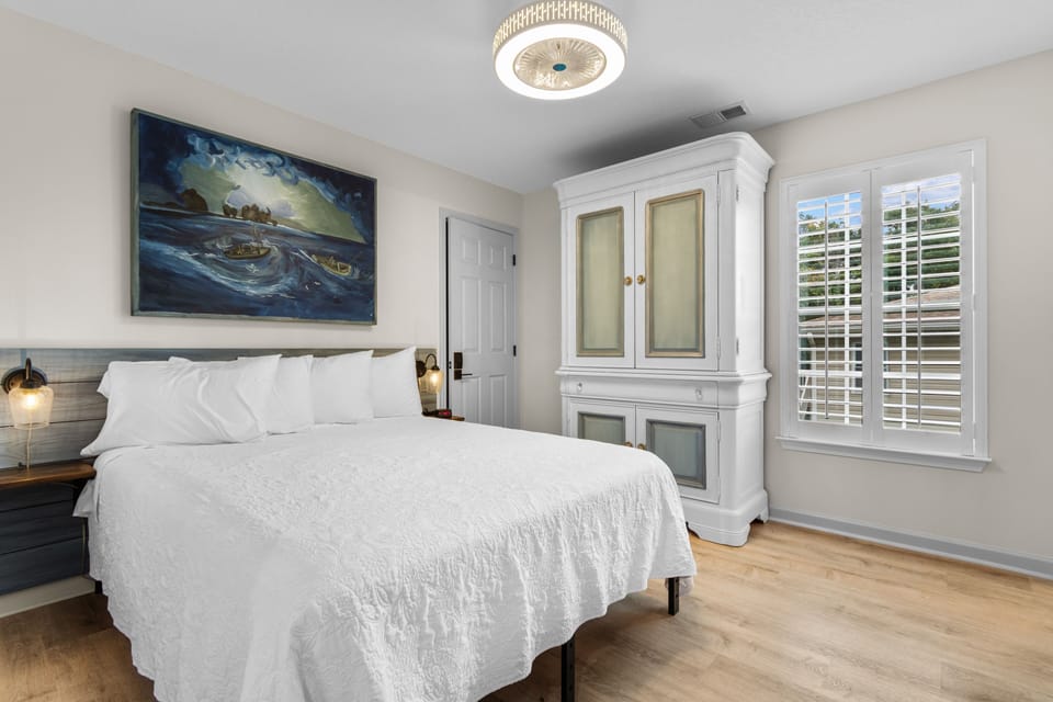 Drift into peaceful sleep in your coastal-themed bedroom, featuring crisp white linens, elegant furnishings, and artwork that whispers of ocean adventures.