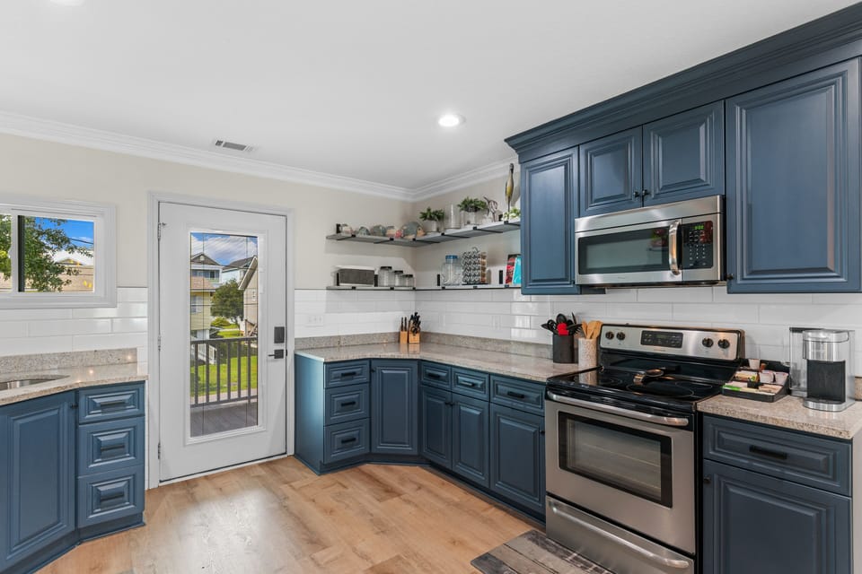 Your stylish kitchen features rich blue cabinets, granite counters, and stainless appliances - perfect for preparing memorable meals during your stay.