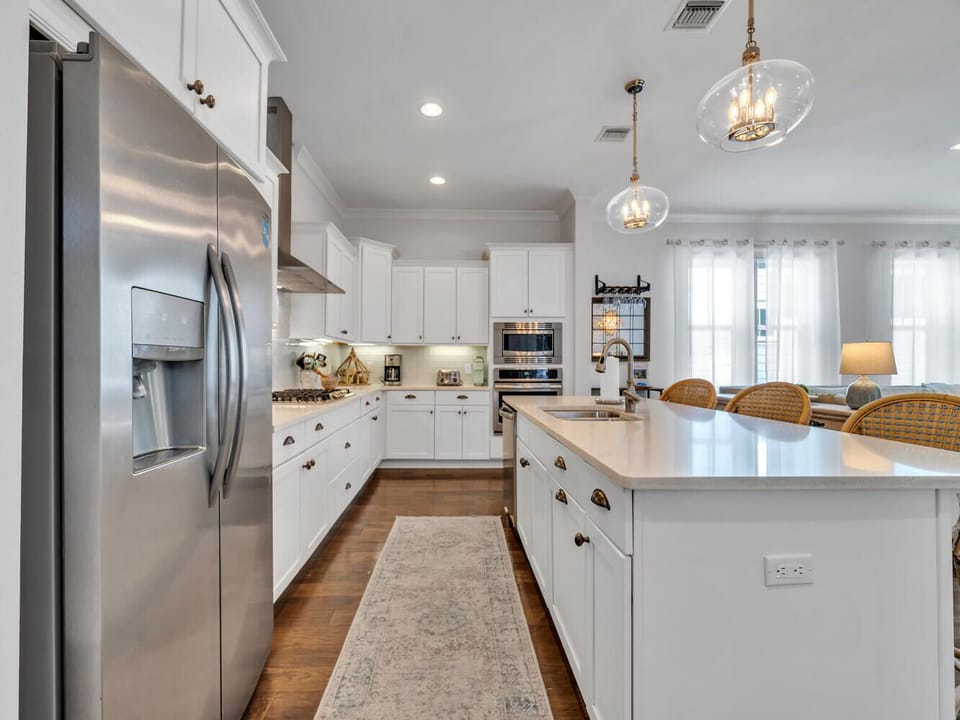 Gather in this bright, fully-equipped kitchen where white cabinets and gleaming countertops create the perfect space for cooking memorable meals together.
