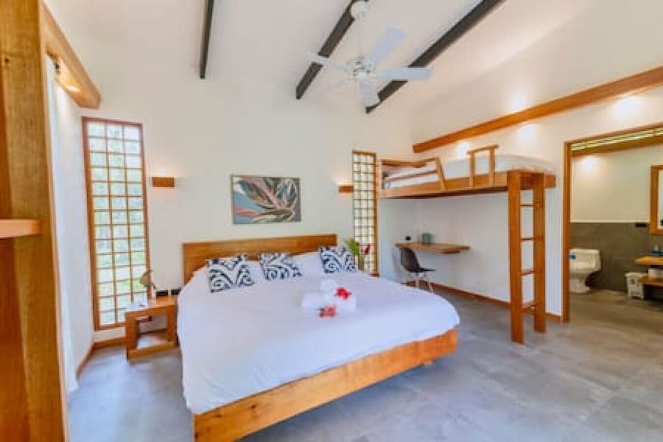 Bright and spacious bedroom with king bed, bunk bed and workspace, Tres Lodge Lapa in Playa Chiquita, Costa Rica