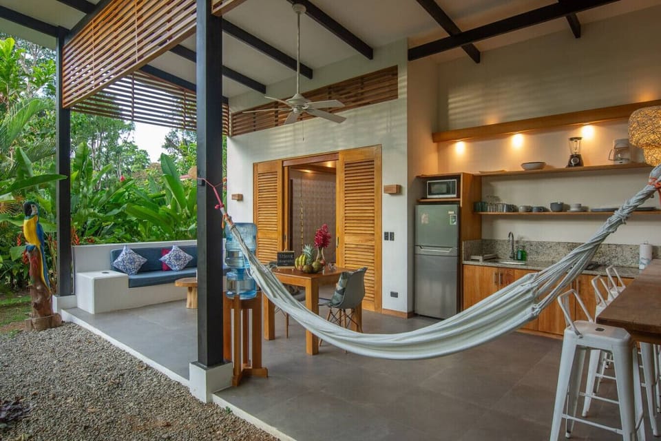 Open-concept living area with kitchen, hammock and tropical garden views, Tres Lodge Lapa in Playa Chiquita, Costa Rica