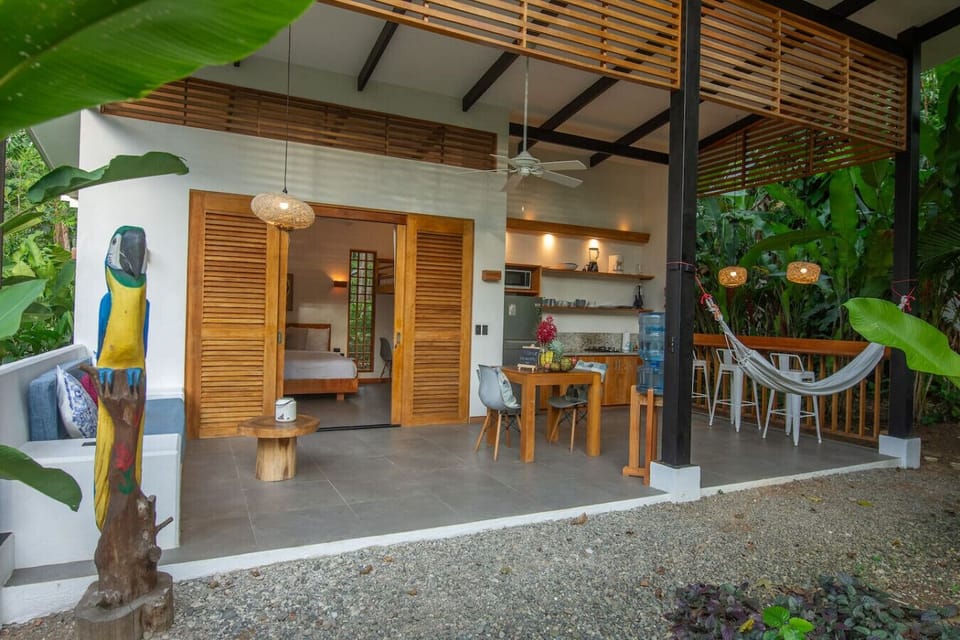 Open-concept villa with living area, kitchen and hammock surrounded by tropical nature, Tres Lodge Lapa in Playa Chiquita, Costa Rica