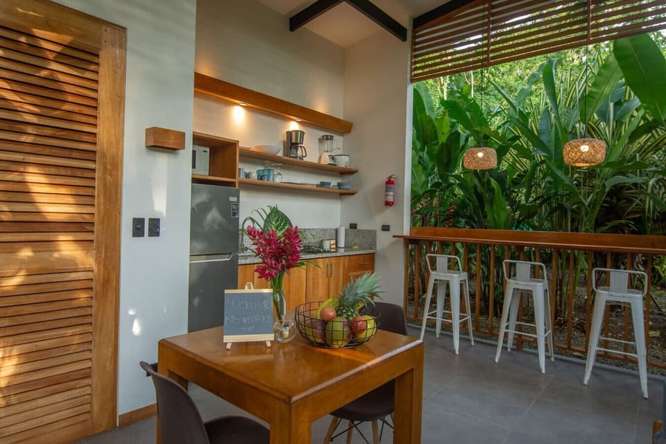 Cozy dining area with fully equipped kitchen and jungle views at Tres Lodge Tucan, Playa Chiquita, Costa Rica