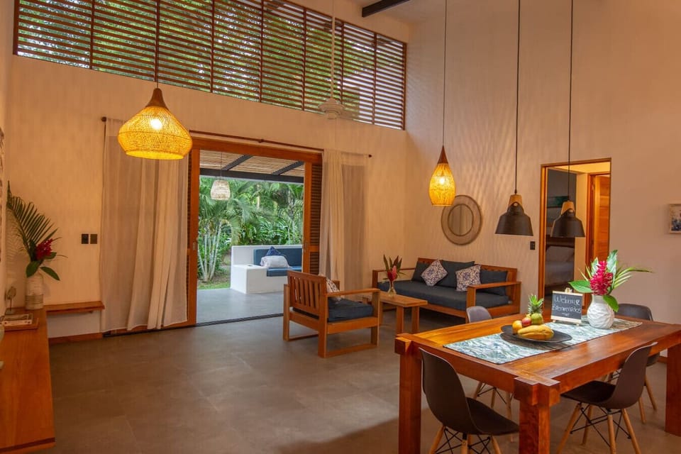 Open-concept living and dining area with high ceilings and tropical design, Tres Lodge Villa in Playa Chiquita, Costa Rica