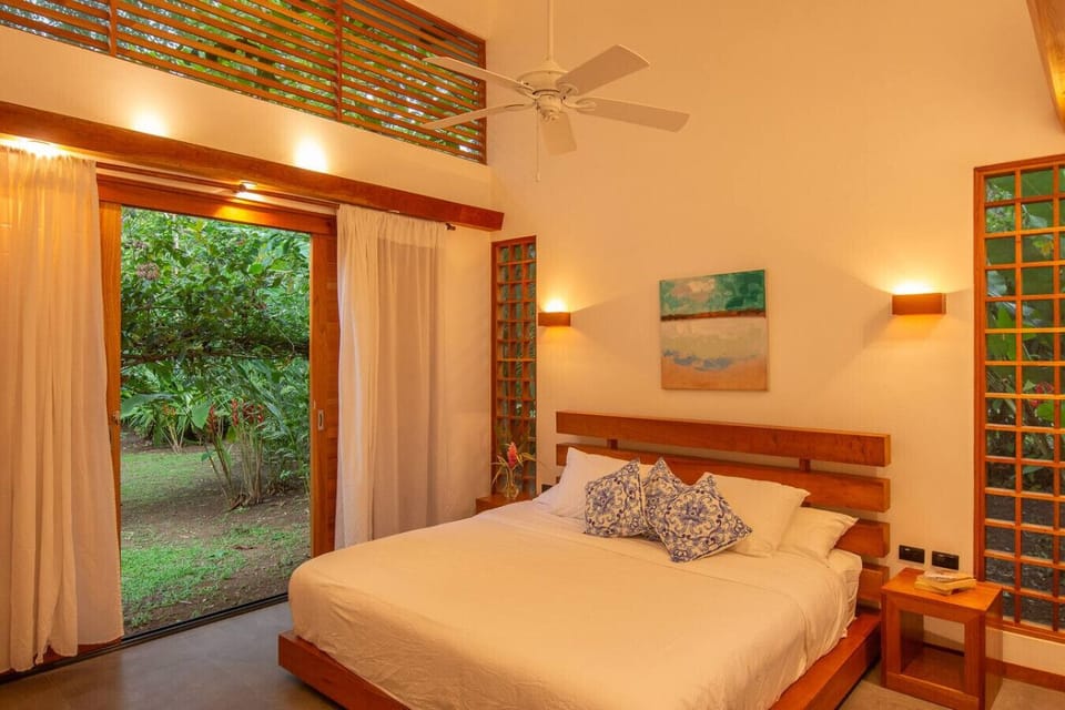 Bright bedroom with king bed and peaceful garden views, Tres Lodge Villa in Playa Chiquita, Costa Rica