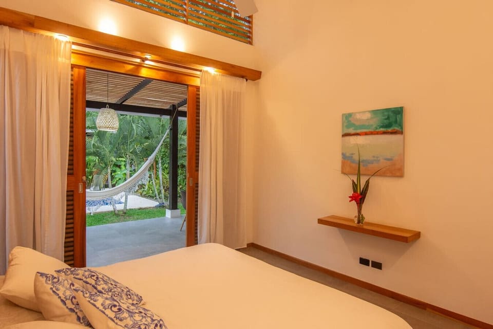 Bedroom with direct access to the terrace, pool and tropical garden views, Tres Lodge Villa in Playa Chiquita, Costa Rica
