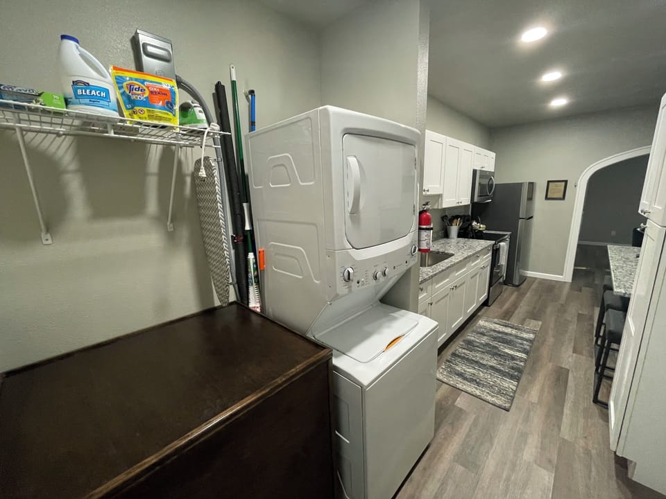 Utility area with washer, dryer, and ironing board