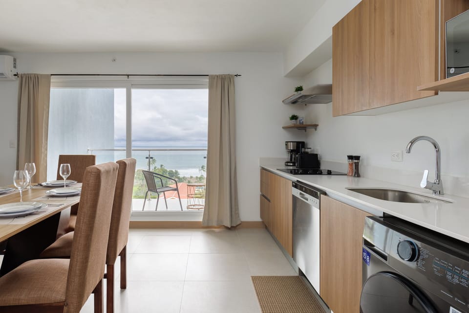 Fully-furnished kitchen and dining area with ocean views