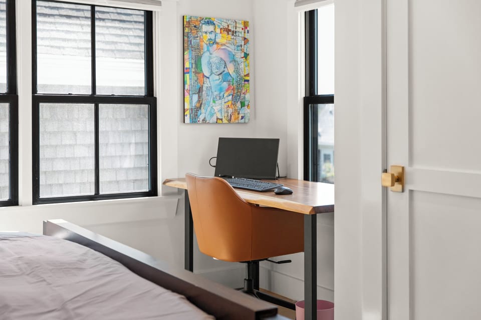 Discover a modern bedroom with a stylish workspace and external monitor.