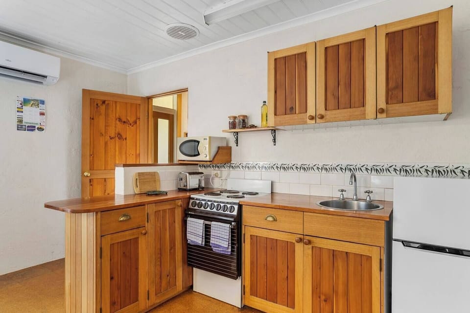 A streamline, timber-benched kitchen offers all the essentials you might need to prepare delicious meals at home.
