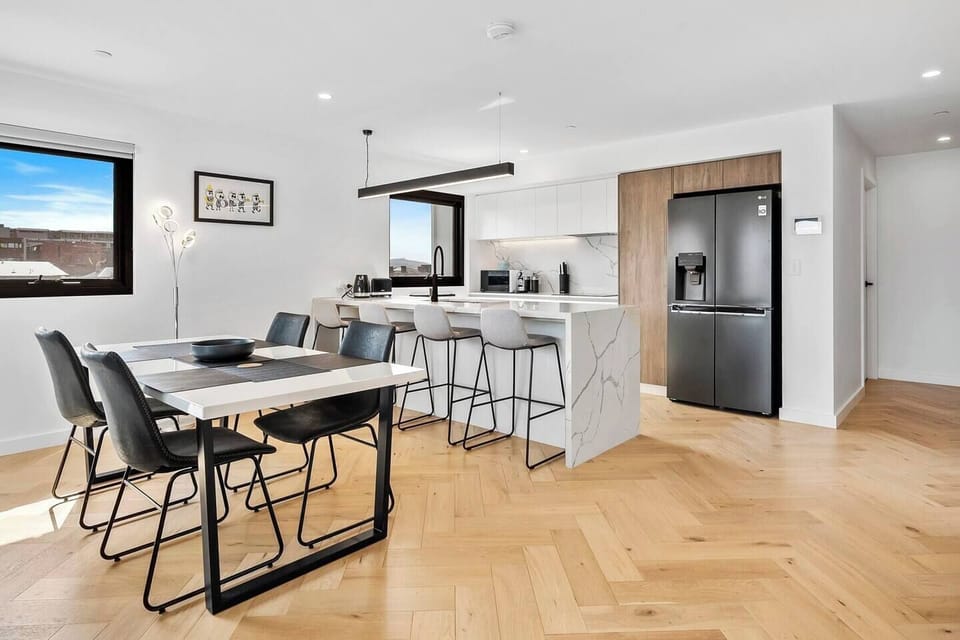 Gather around the dining table for four, ideal for intimate meals and conveniently located adjacent to the kitchen and living area.