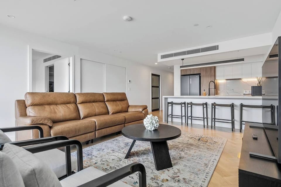Relax in the spacious living room, featuring a comfortable three-seater reclining leather lounge perfect for lazing in front of the TV.