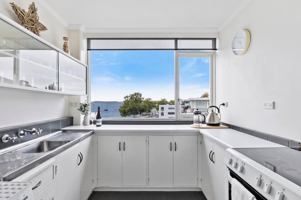 The kitchen is flooded with natural light, with windows framing the river, allowing you to enjoy the morning and beautiful surroundings as you prepare your breakfast.