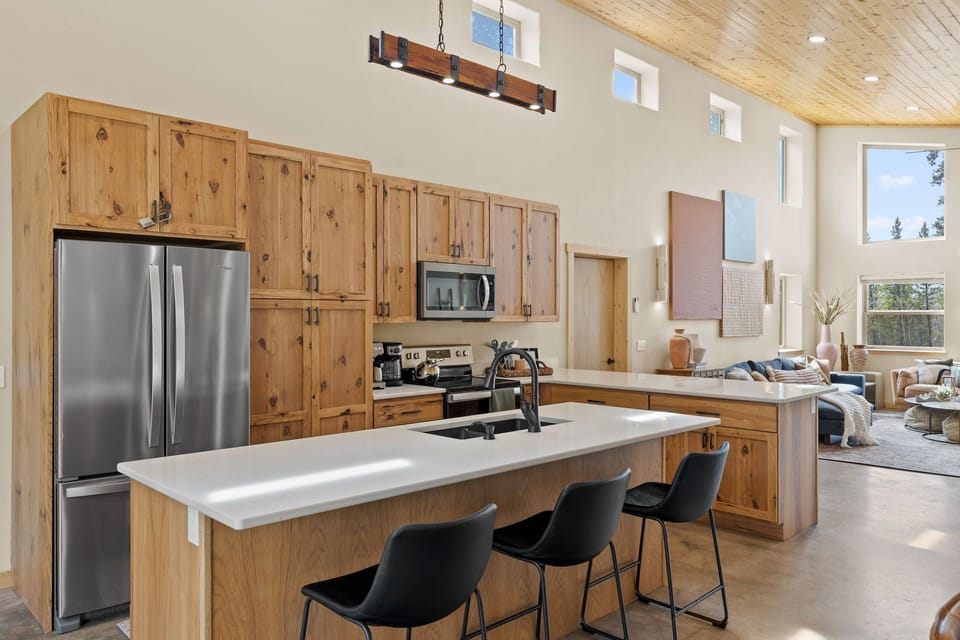 Large kitchen with 6 stools and 2 islands, open to living + dining areas