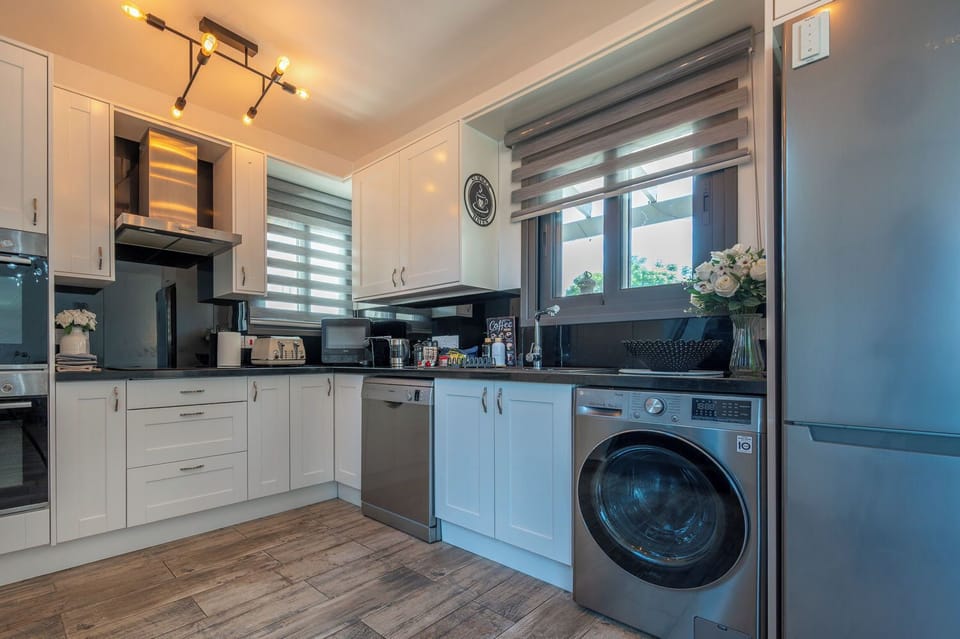 Fully equipped kitchen with modern appliances and a washing machine