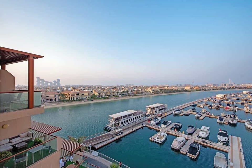 Views over a marina onto the Palm Jumeirah and iconic buildings including the Royal Atlantis and Burj Al Arab 