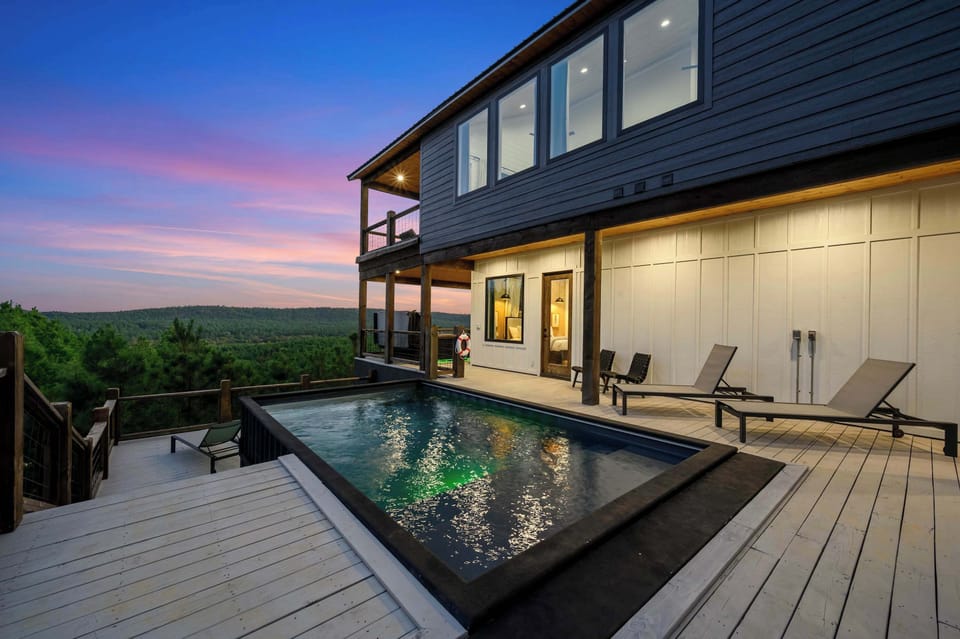 Scenic luxury cabin with illuminated private pool and sunset views—relax in comfort and style.