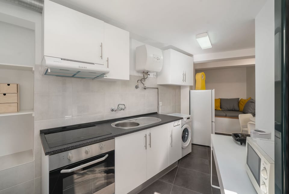 The Modern Kitchen And Washing Machine At Vintage Garden Apartment By Ourmadeira
