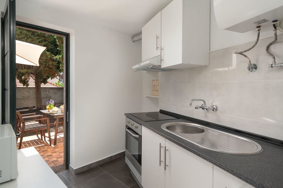 The Modern Kitchen At Vintage Garden Apartment By Ourmadeira Showing The Garden And Outdoor Dining Area