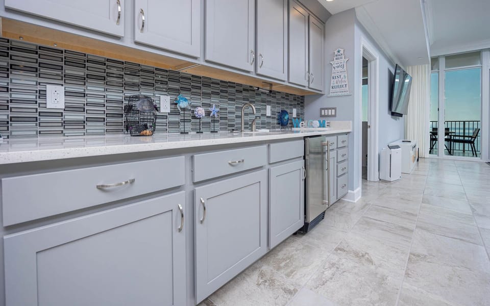 Grab a chilled drink from the fridge or create your favorite cocktail at the wet bar with charming coastal accents