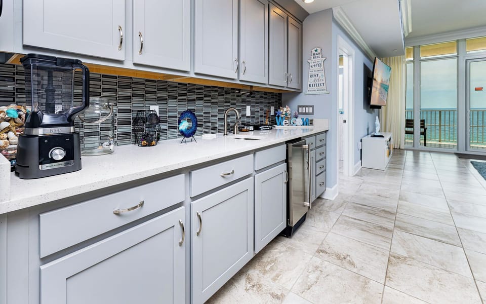 Grab a chilled drink from the fridge or create your favorite cocktail at the wet bar with charming coastal accents